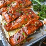 Salmon sheet pan dinner on a baking tray with brocolini.