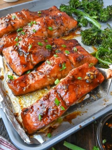 Salmon sheet pan dinner on a baking tray with brocolini.