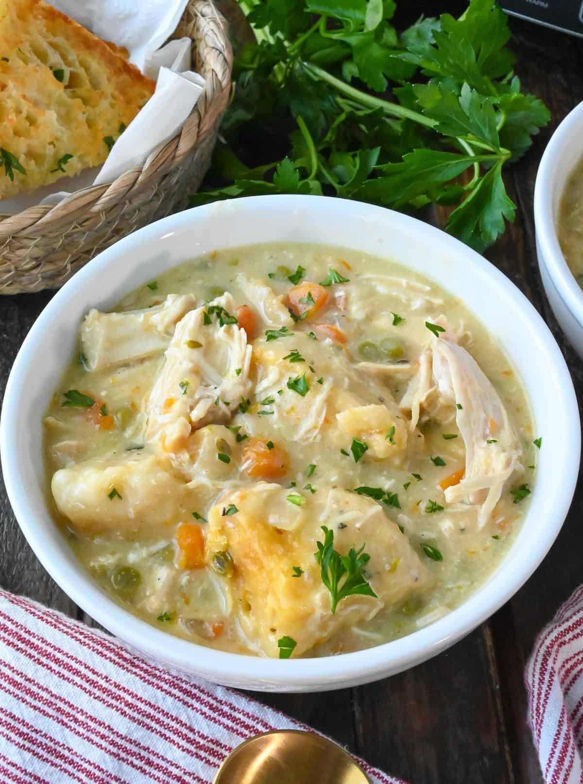 Chicken and dumplings in a white bowl.