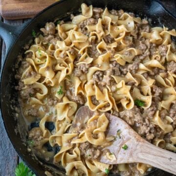 Beef and noodles in a cast iron skillet.