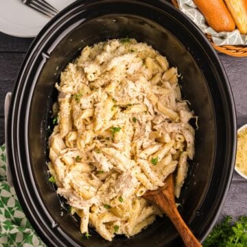 Top down view of a slow cooker full of olive garden chicken pasta.