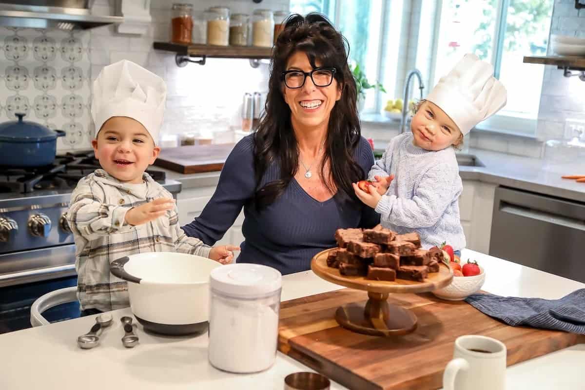 A picture of me cooking in the kitchen with my grandkids.