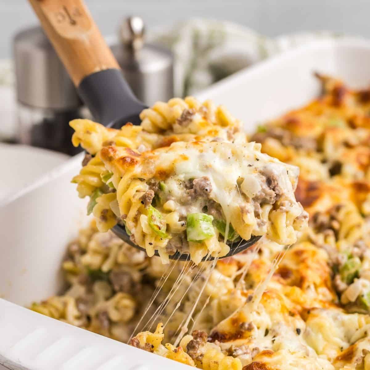 A serving of casserole being lifted on a spatula from the baking dish