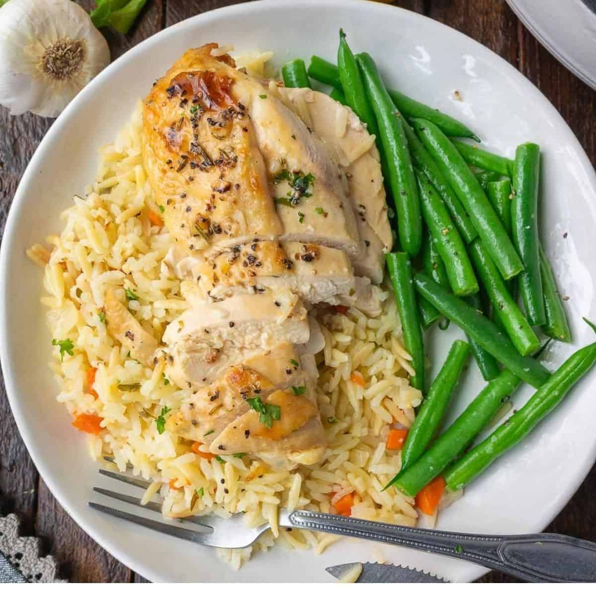 Healthy chicken dinner on a plate with steamed green beans.