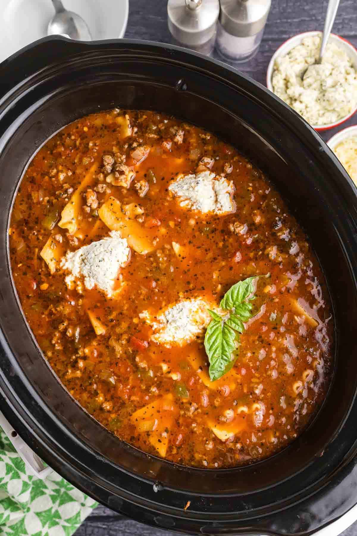 Overhead view of a crockpot full of lasagna soup.