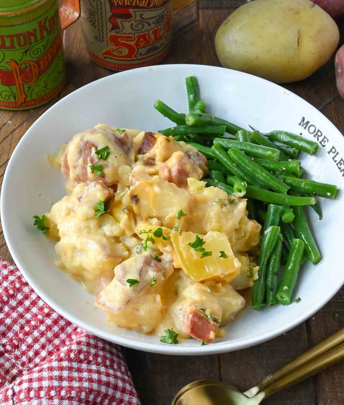 Ham and potatoes on a plate with green beans.