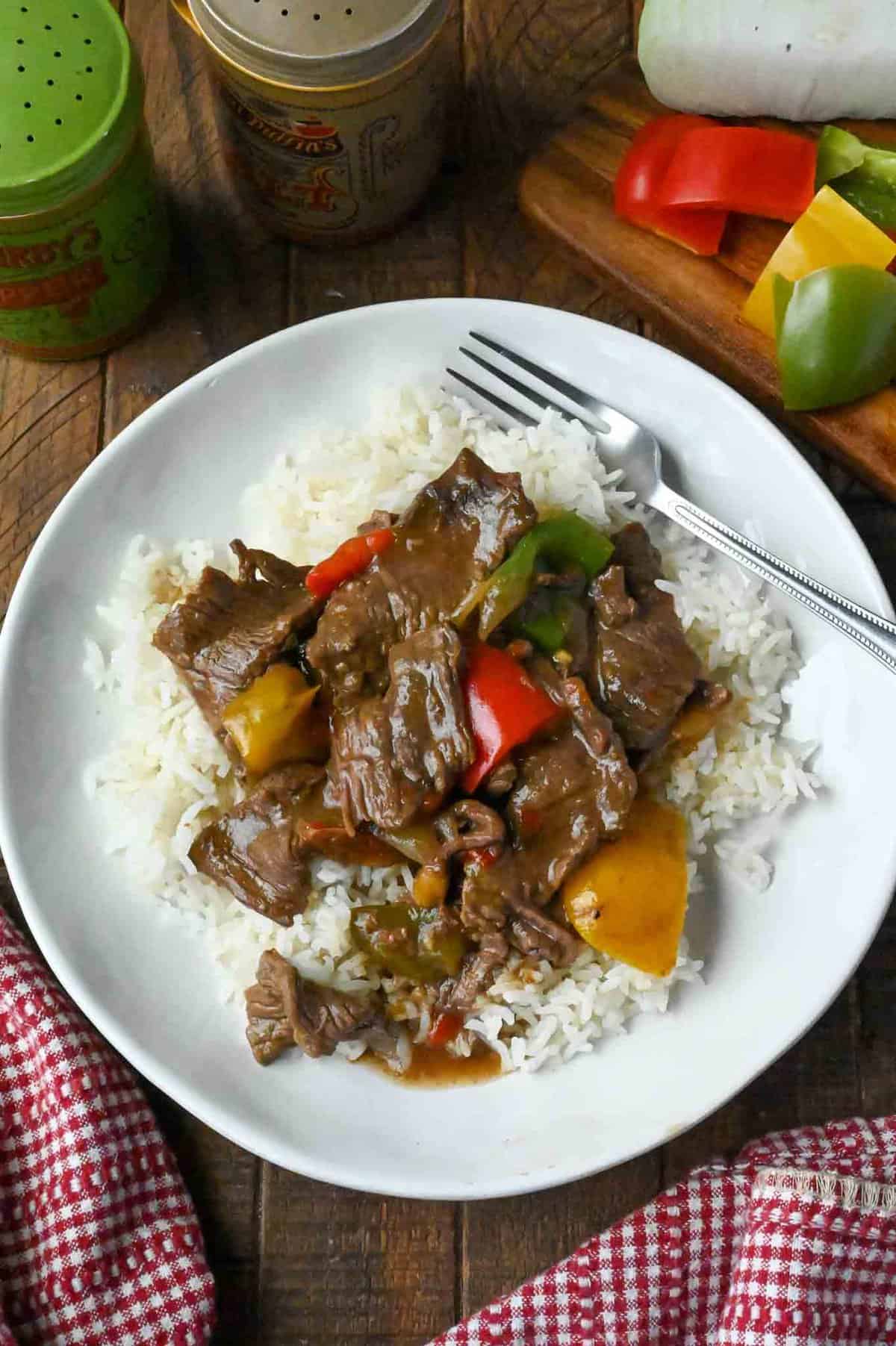 A plate of slow cooker pepper steak with white rice.