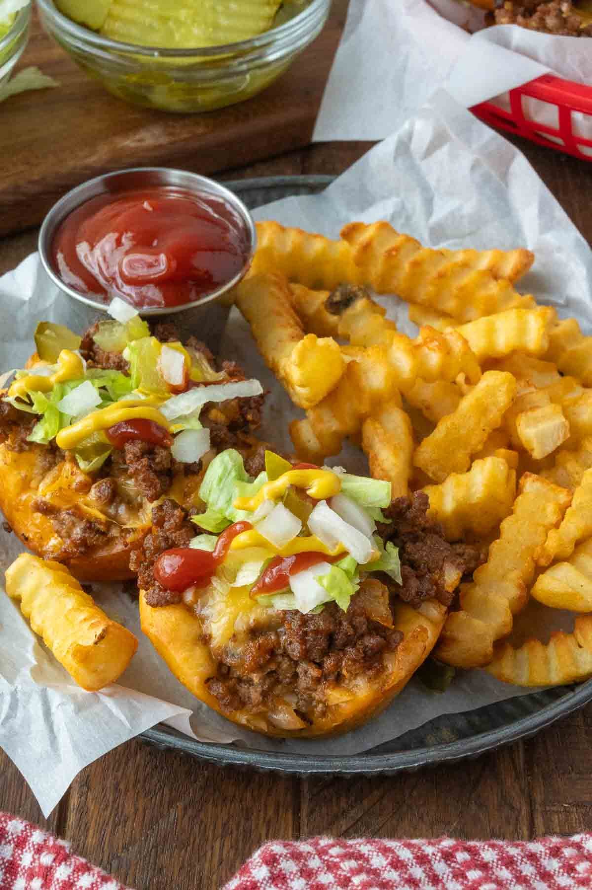 Cheeseburger cups on a plate with french fries and a cup of ketchup.