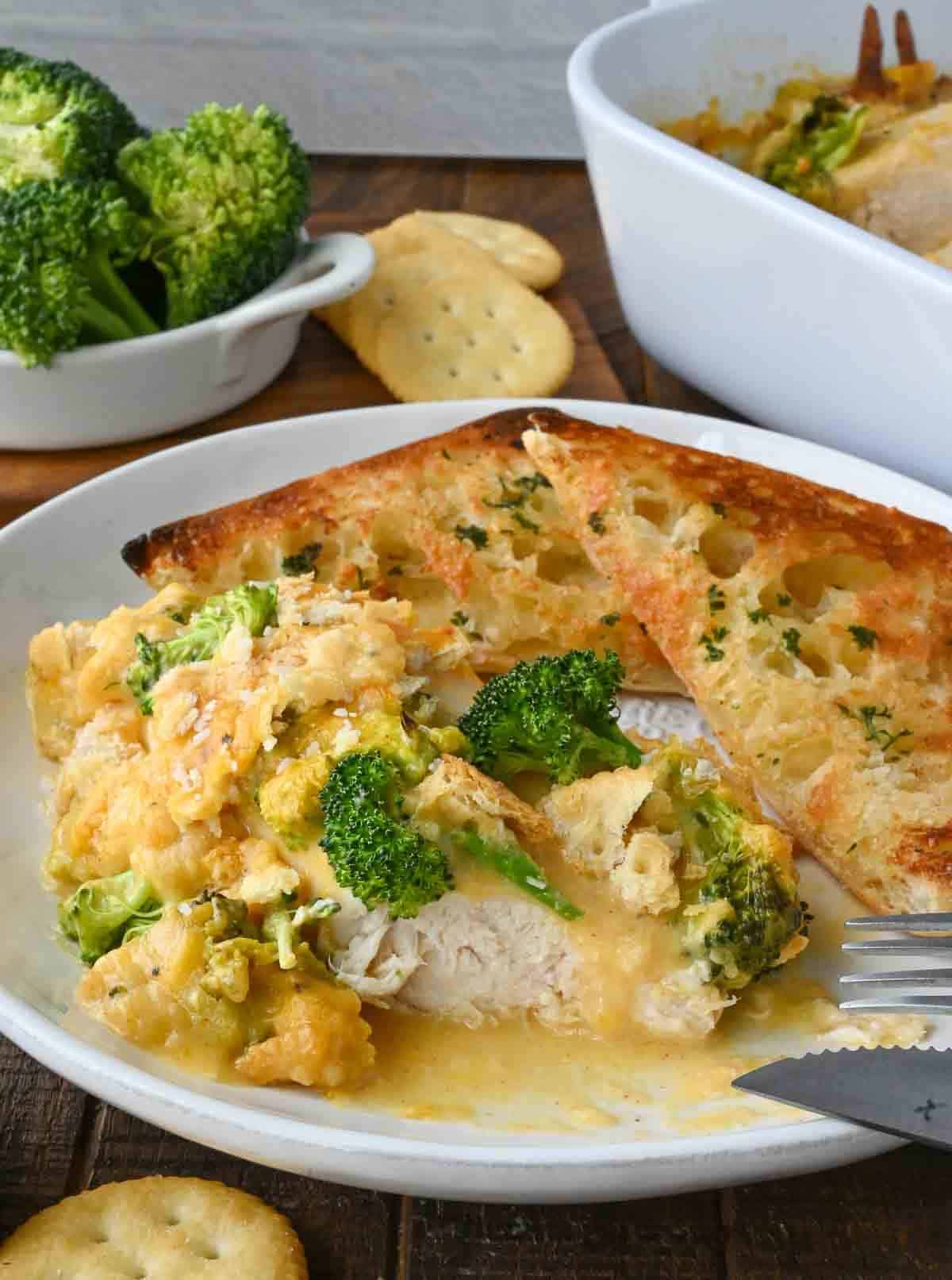 A plate of broccoli cheddar chicken with toasted ciabatta.