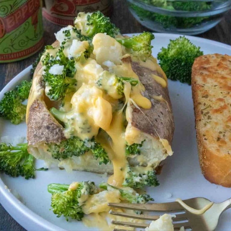 Broccoli cheese baked potato on a white plate.