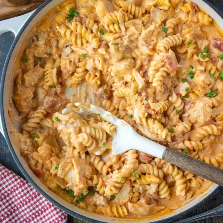 Buffalo chicken pasta in a skillet with a serving spoon.