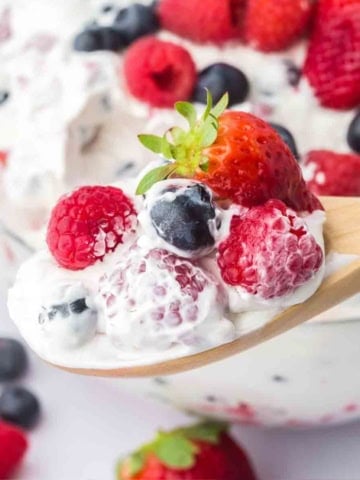 A spoonful of cheesecake salad with fruit.
