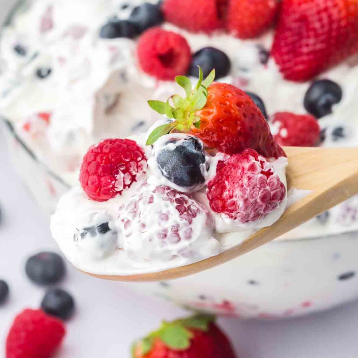 A spoonful of cheesecake salad with fruit.