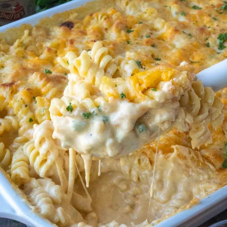 Scooping up 5 cheese mac and cheese from a baking dish.
