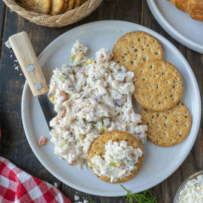 A plate of feta chicken salad with crackers.