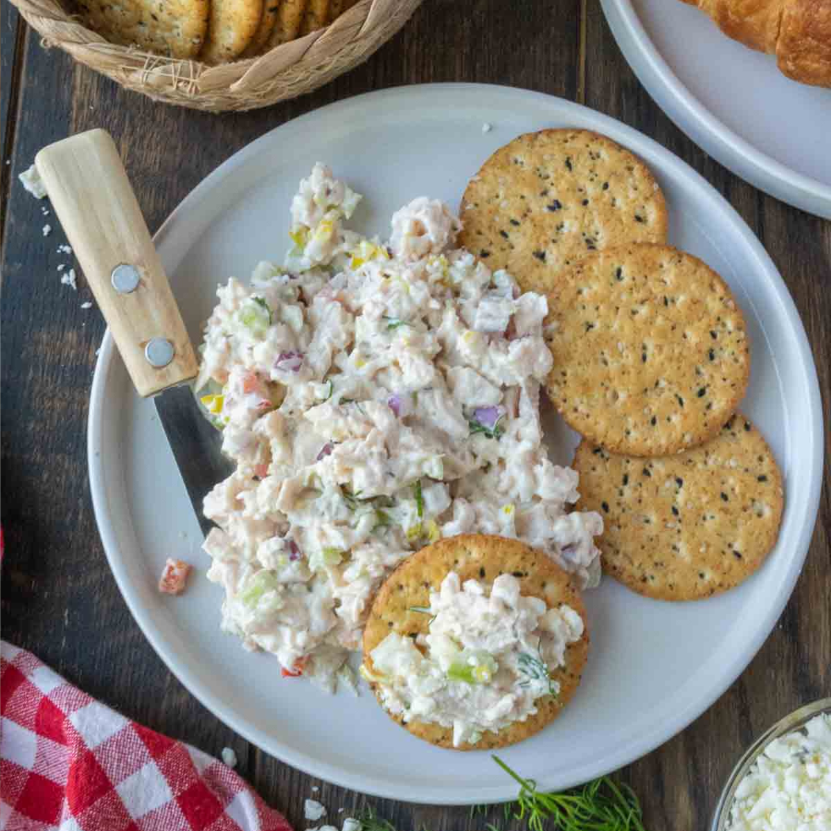 A plate of feta chicken salad with crackers.