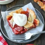 Strawberry slab pie on a plate with a dollop of whipped cream.