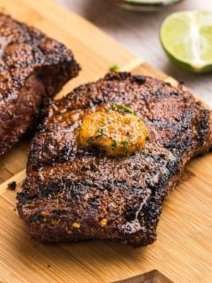 Grilled top sirloin steak on a wooden platter.