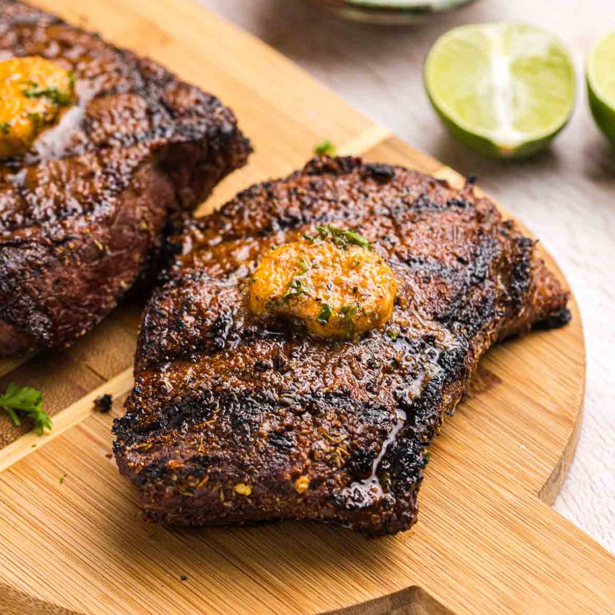 Grilled top sirloin steak on a wooden platter.