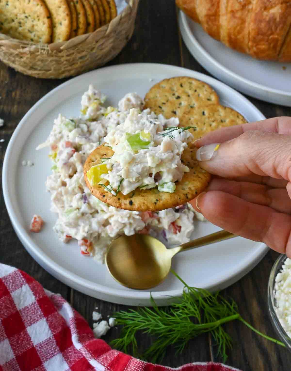 Scooping up feta chicken salad with a cracker.