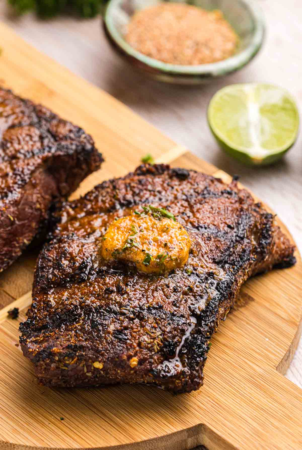 A piece of grilled sirloin steak with a pat of cajun butter.