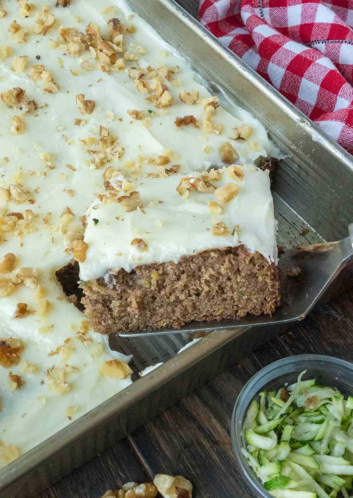 A spatula picking up a piece of zucchini cake recipe.