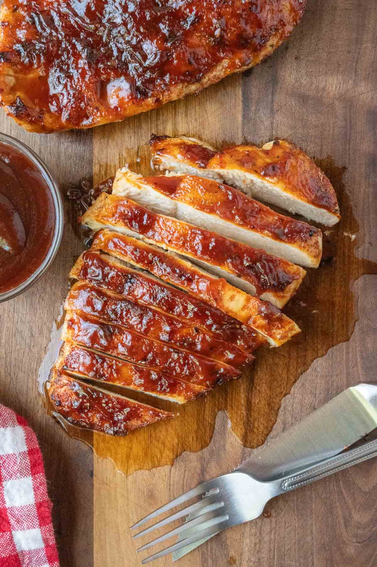 Sliced air fryer BBQ chicken on a cutting board.