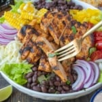 Taking a piece of southwestern chicken with a fork.