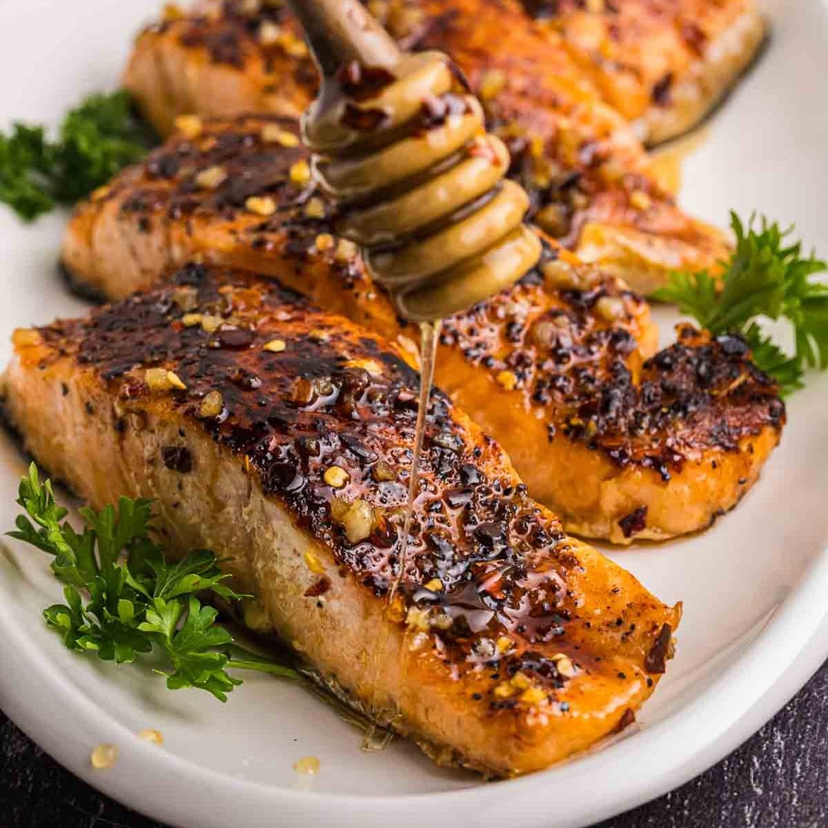 Drizzling honey over hot honey salmon.