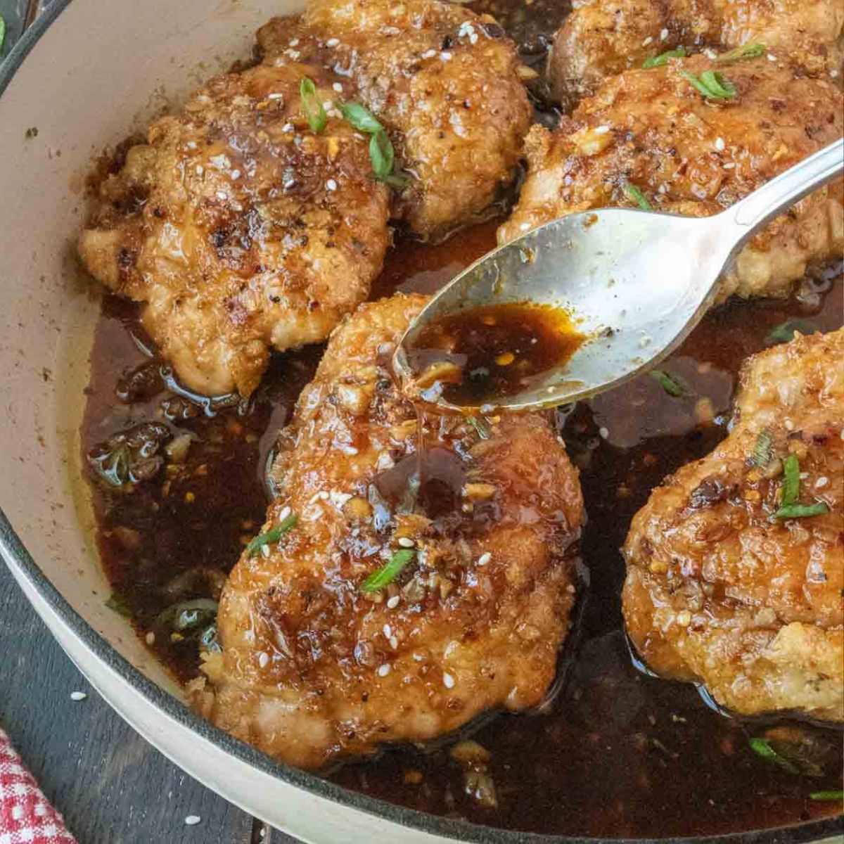 Spooning sauce over crispy soy garlic chicken thighs.