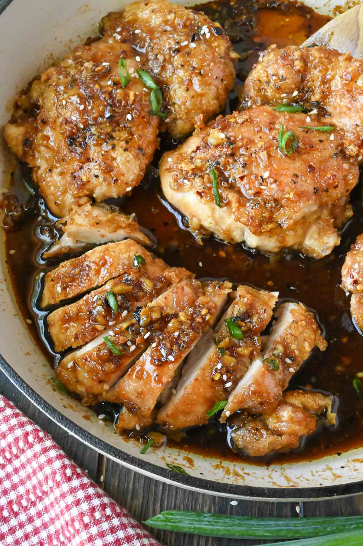 A skillet with soy garlic chicken thighs.