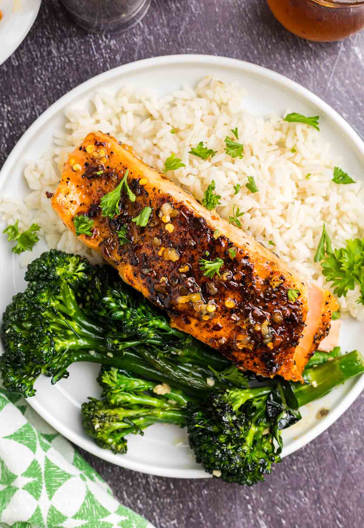 A plate of hot honey salmon with rice and broccoli.