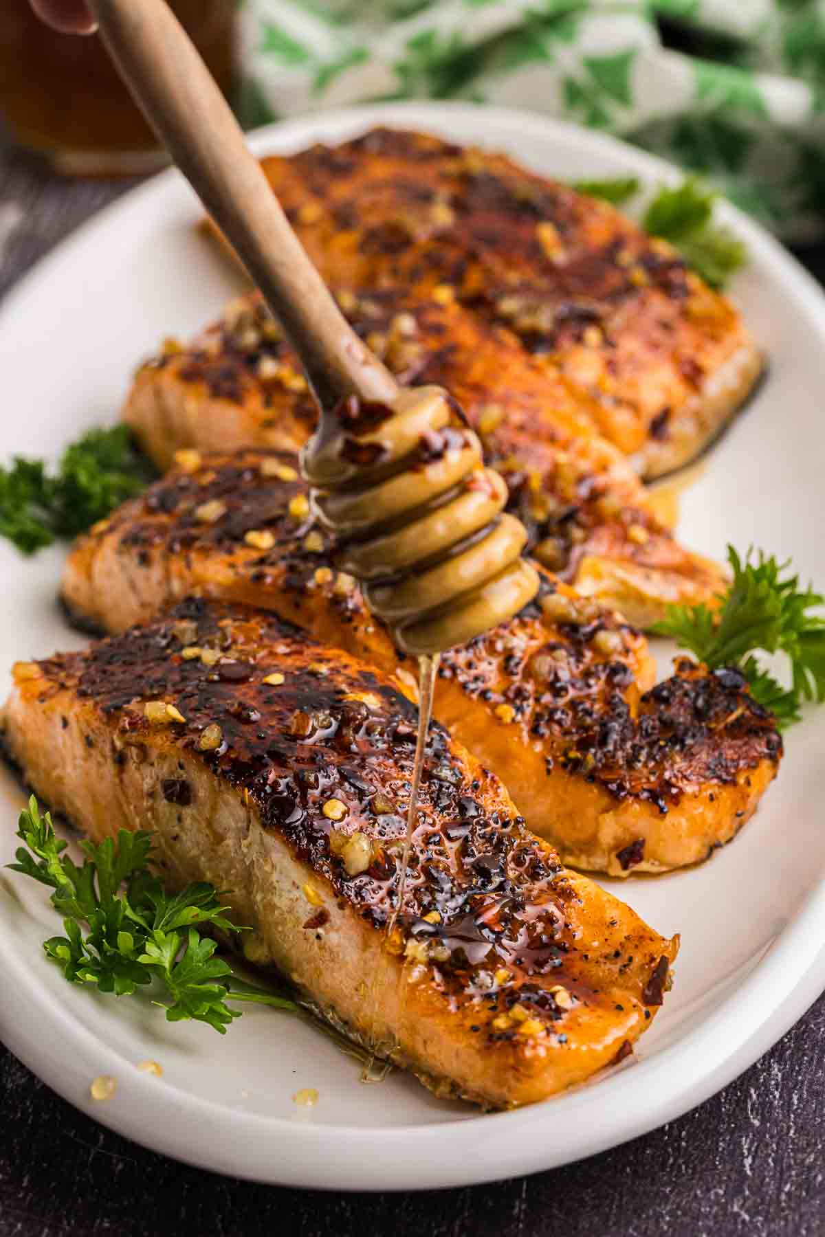 Drizzling honey over a platter of hot honey salmon.