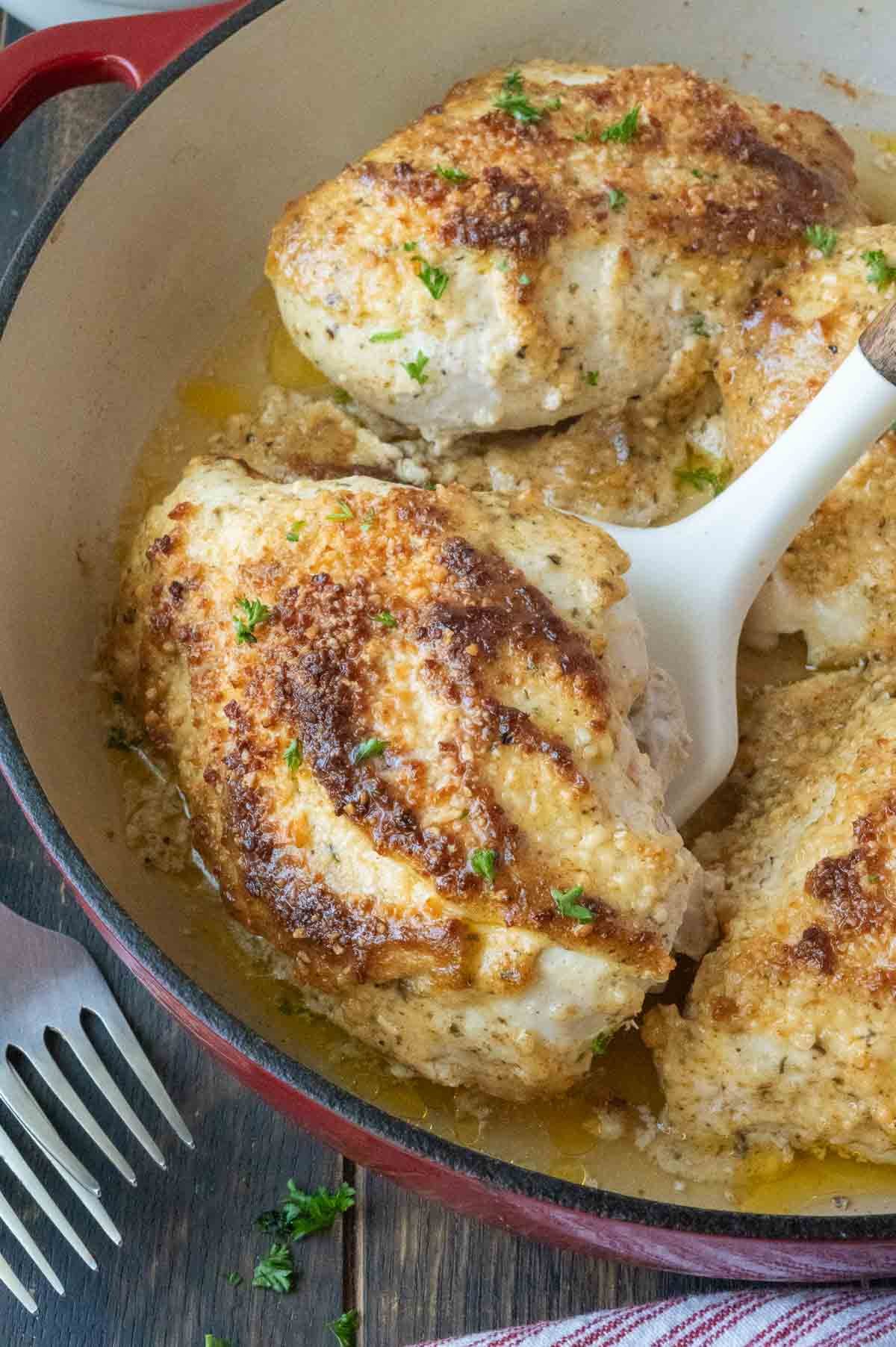 Lifting a piece of melt in your mouth chicken out of a skillet.