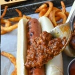 Hot dog chili placed on top of a hot dog.