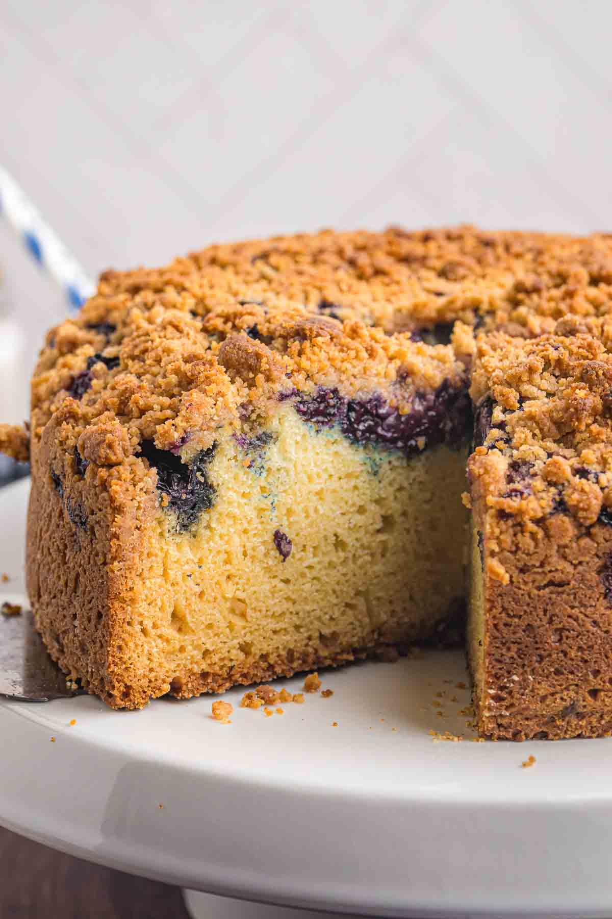A blueberry crumb cake with one slice missing.