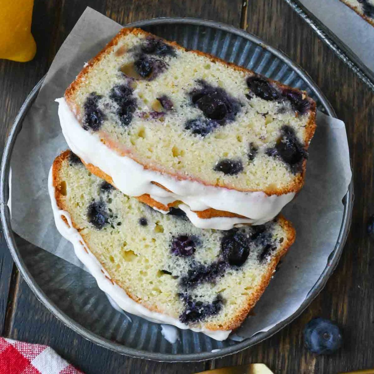 Two pieces of lemon blueberry bread on a plate with a fork.