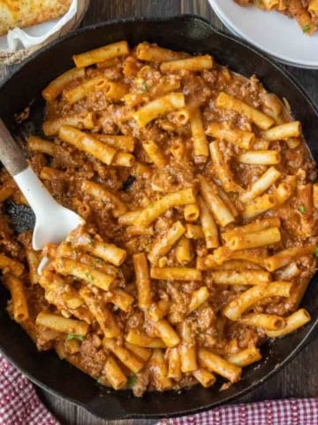 Homemade beefaroni in a skillet with a spatula.