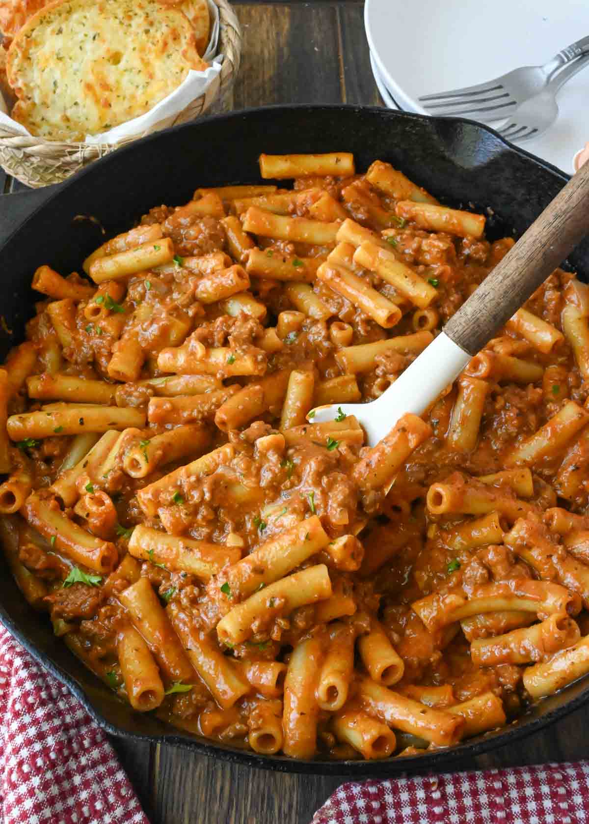 Stirring a skillet of homemade beefaroni.
