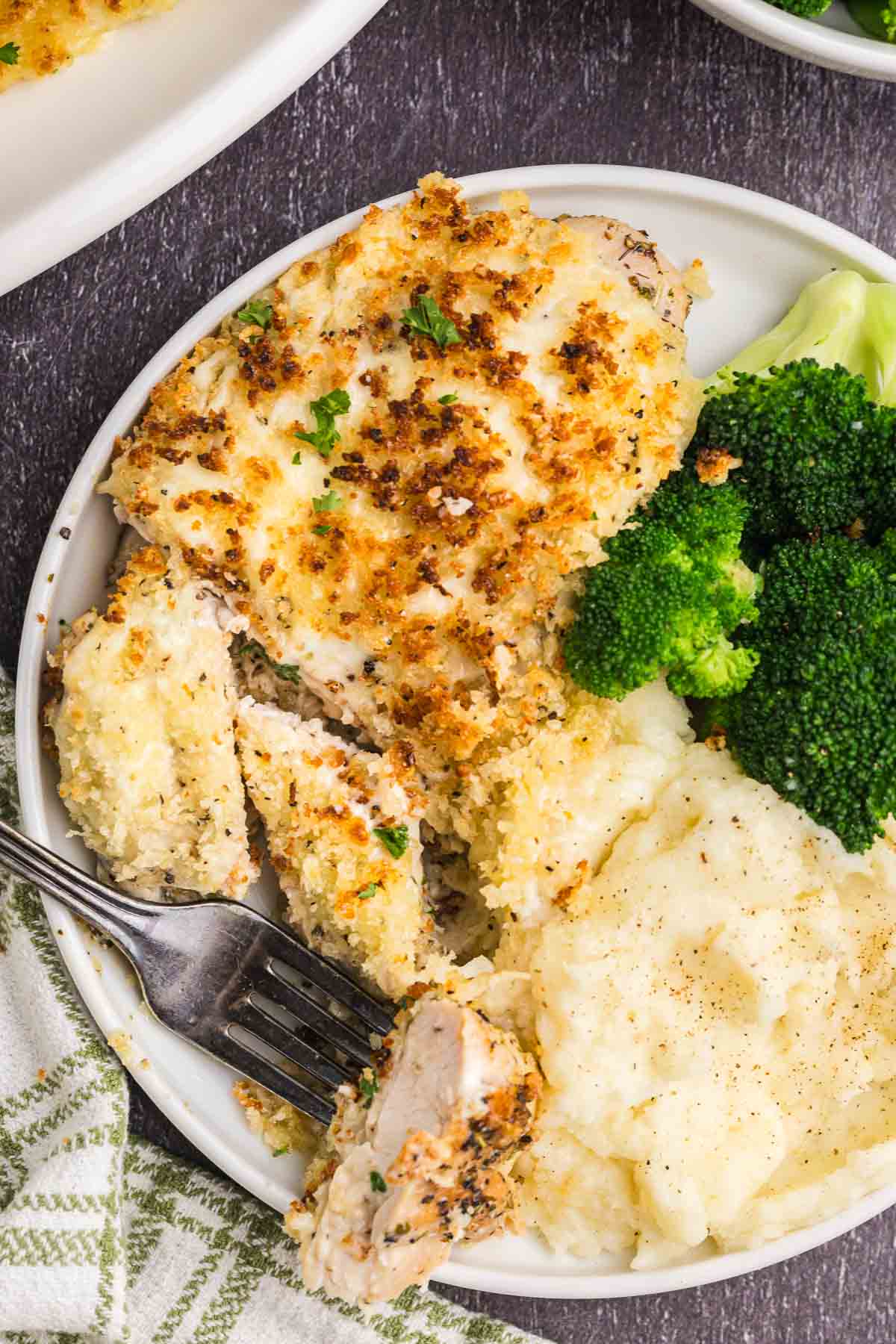 A plate of longhorn steakhouse parmesan crusted chicken with broccoli and mashed potatoes.