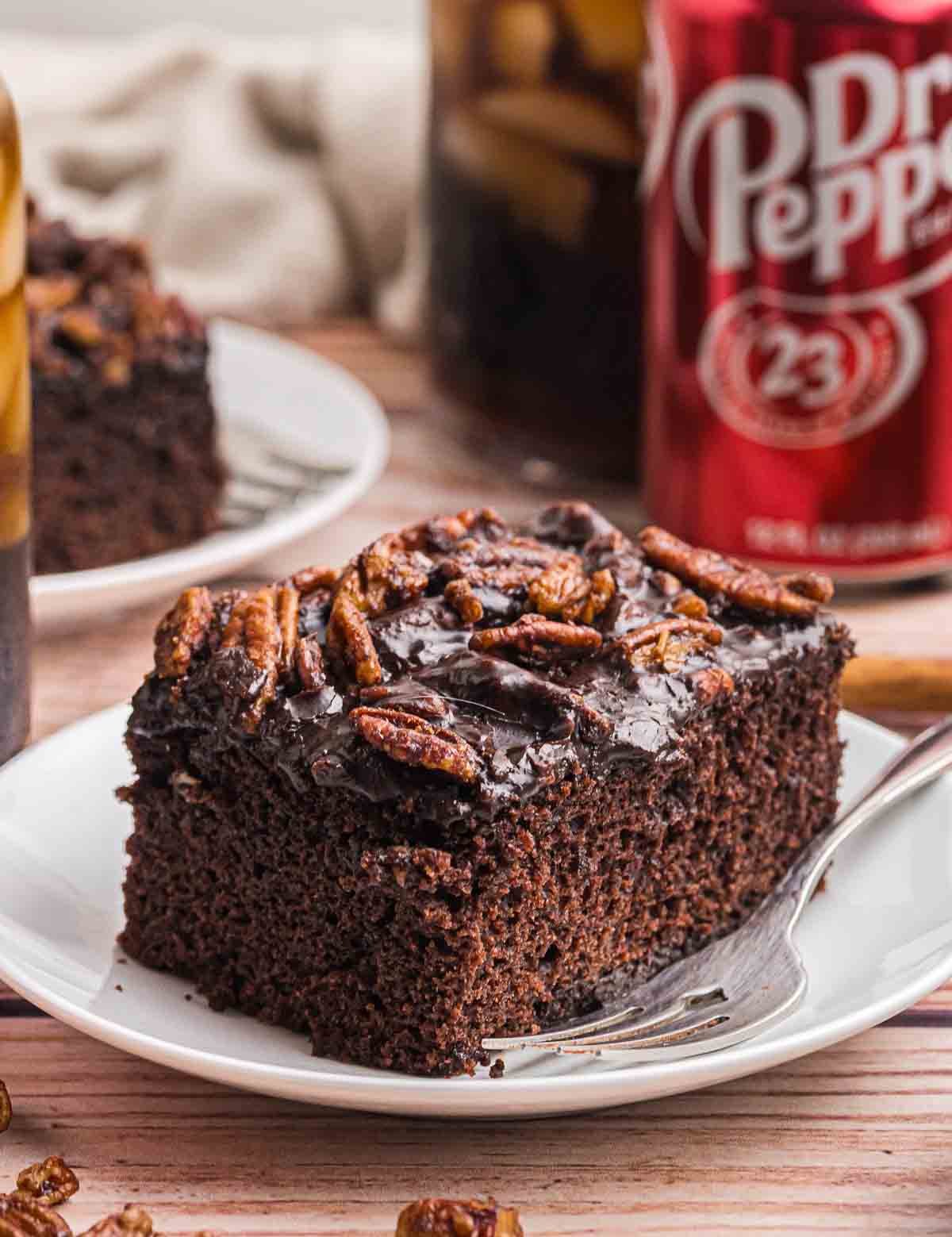 A slice of dr pepper cake on a plate with a fork.