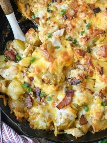 Cheesy potato casserole with a spatula in it.