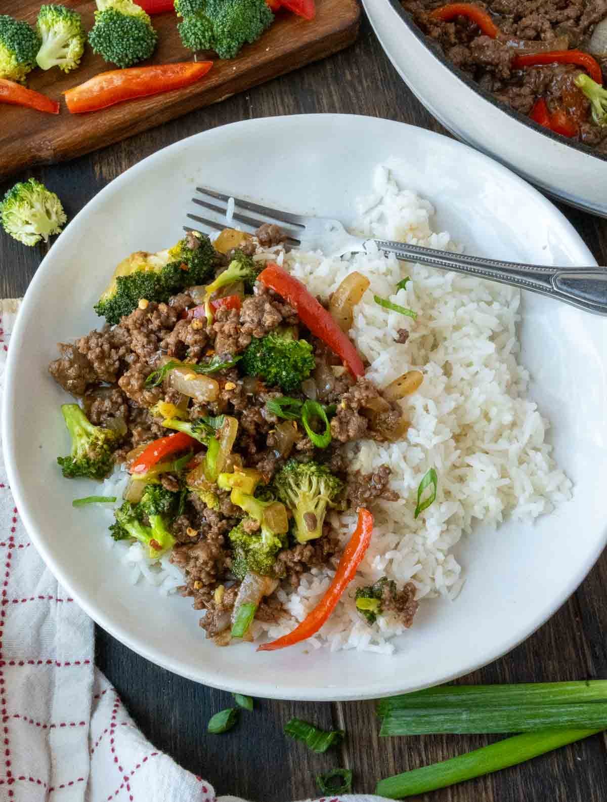 A plate of ground beef and broccoli served over rice.