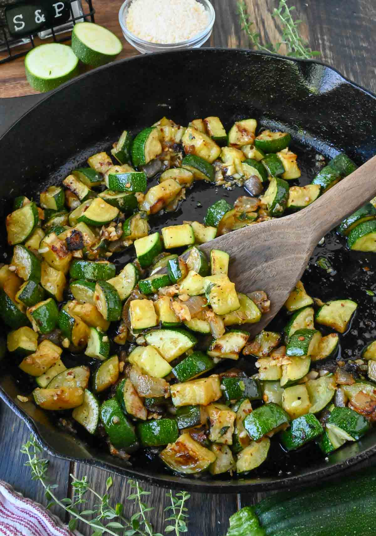 Sauteeing zucchini and onions in a cast iron skillet.