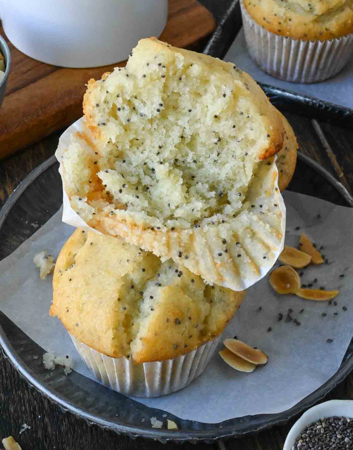 An almond poppy seed muffin cut in half on top of another muffin.