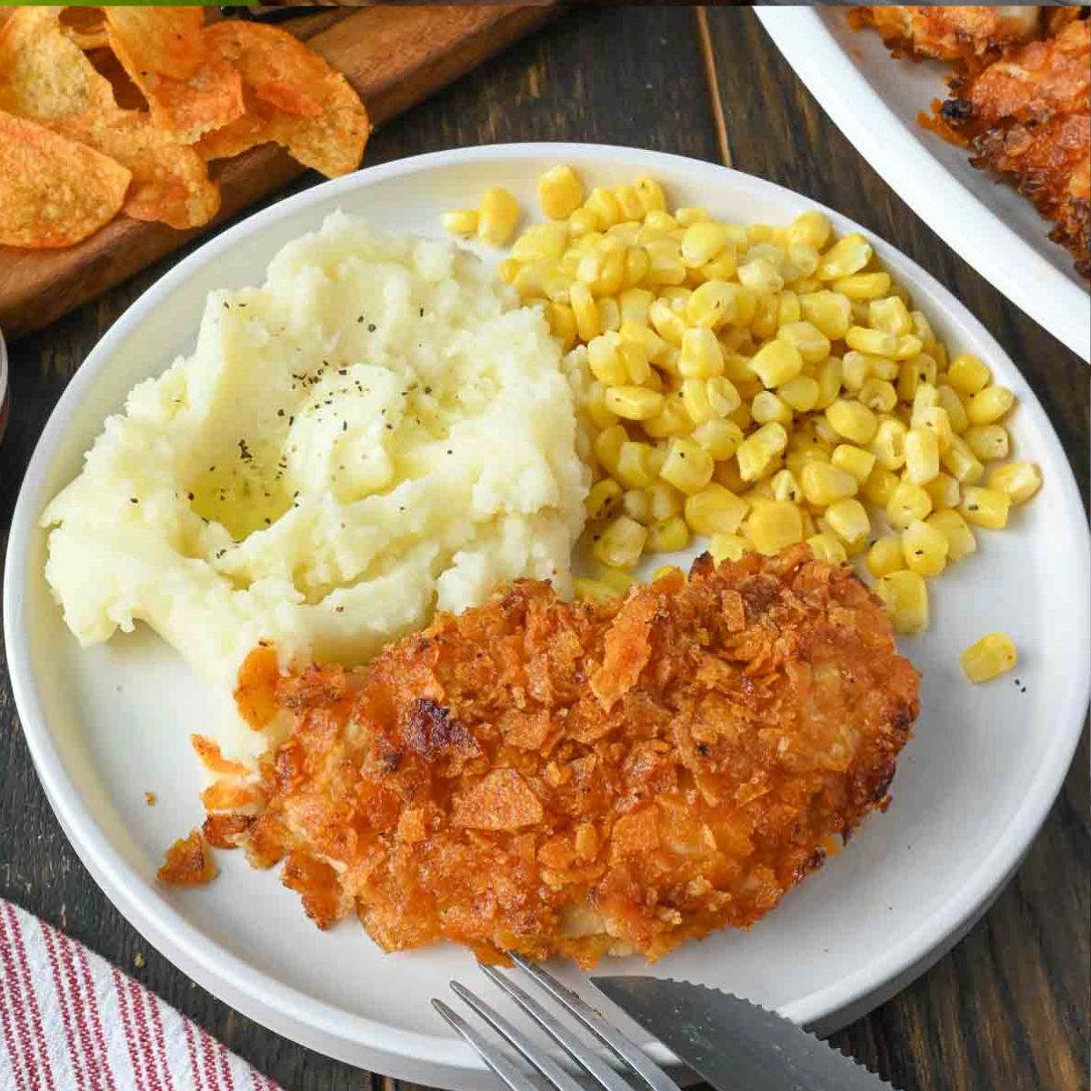 A plate of barbecue chip chicken tenders with corn and mashed potatoes.