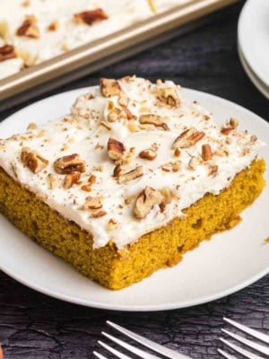 A piece of pumpkin sheet cake on a plate.