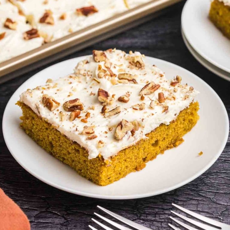 A piece of pumpkin sheet cake on a plate.