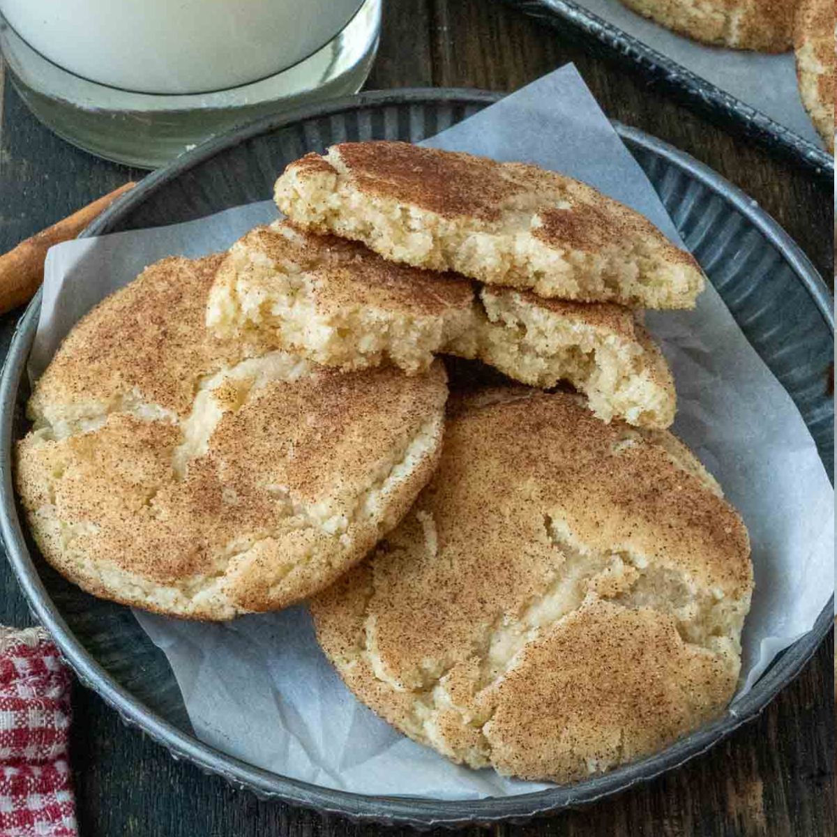 Snickerdoodles on a plate with a glass of milk.