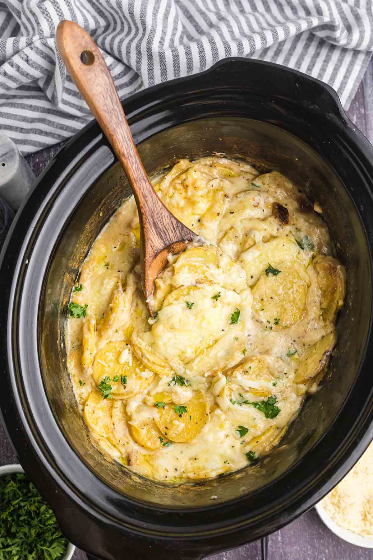 A slow cooker full of scalloped potatoes.
